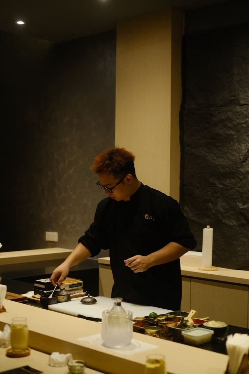 A chef working the counter at DEN Culinary